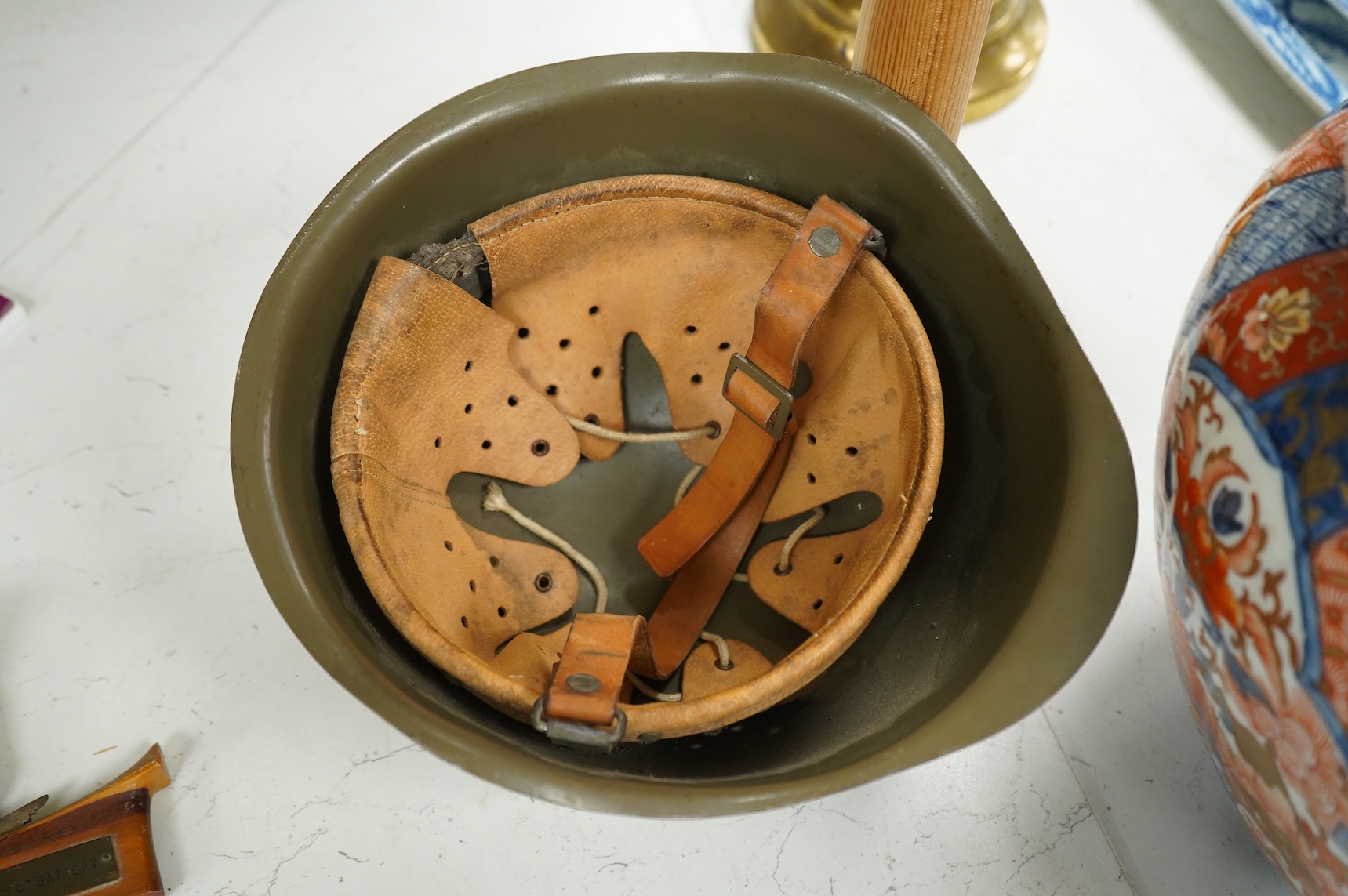 A Czech Vz53 tin helmet with liner, a Kris with applied presentation plaque engraved with ‘Presented by 'C' Battery’ and an inert British Mills hand grenade